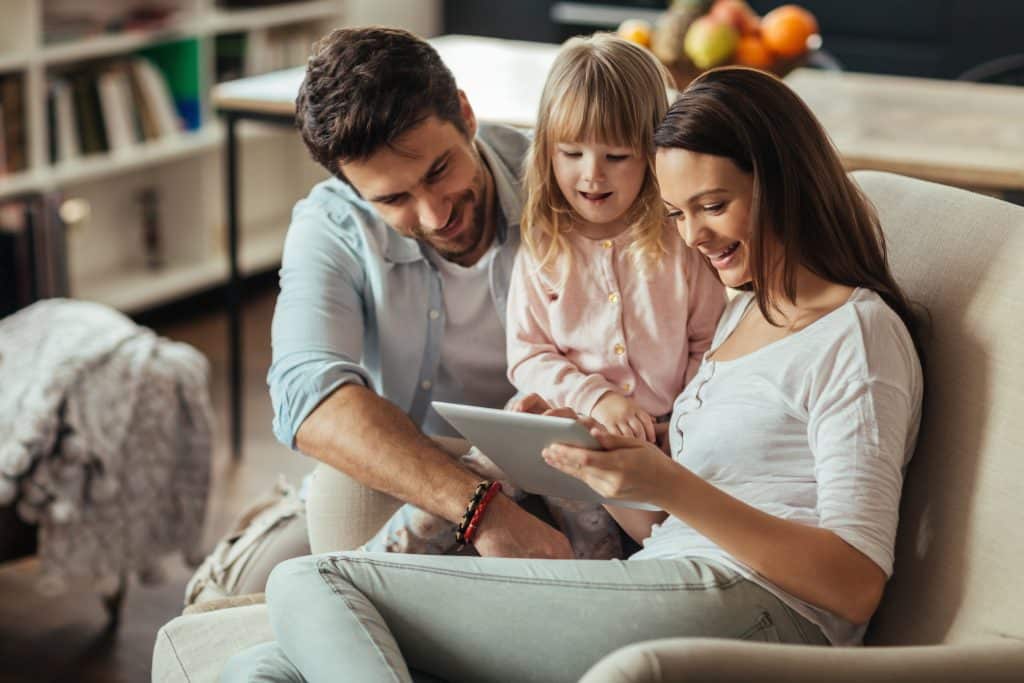 Young family looking digital tablet